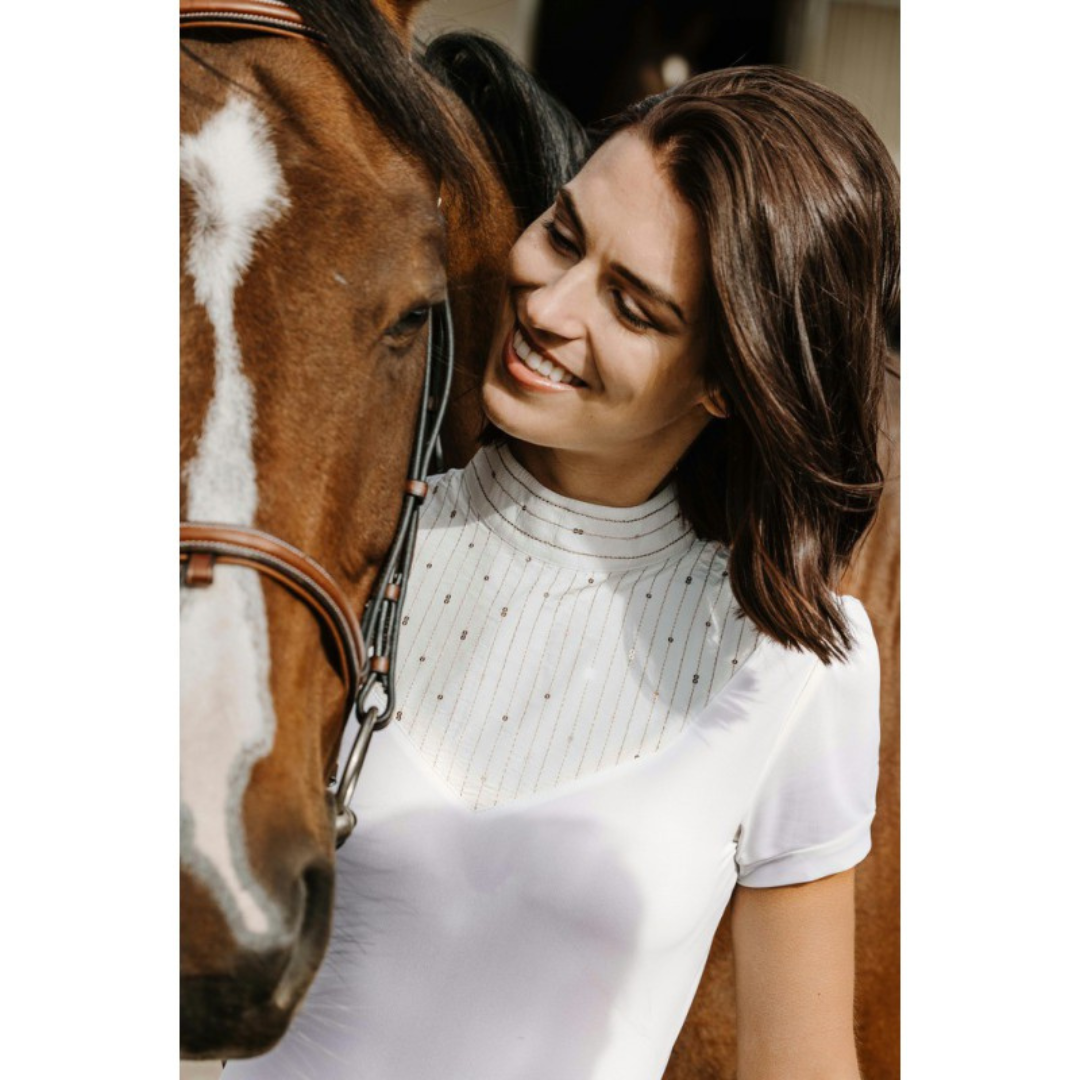 Girl with horse wearing white cotton competition polo shirt with gold sequins on bib front.