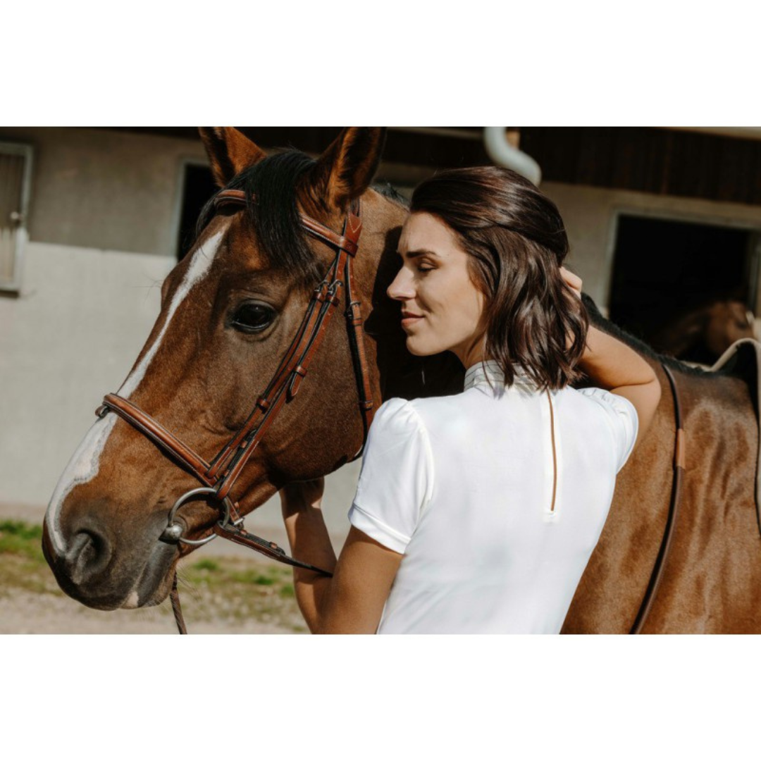 Girl with horse wearing white cotton competition polo shirt with gold sequins on bib front.